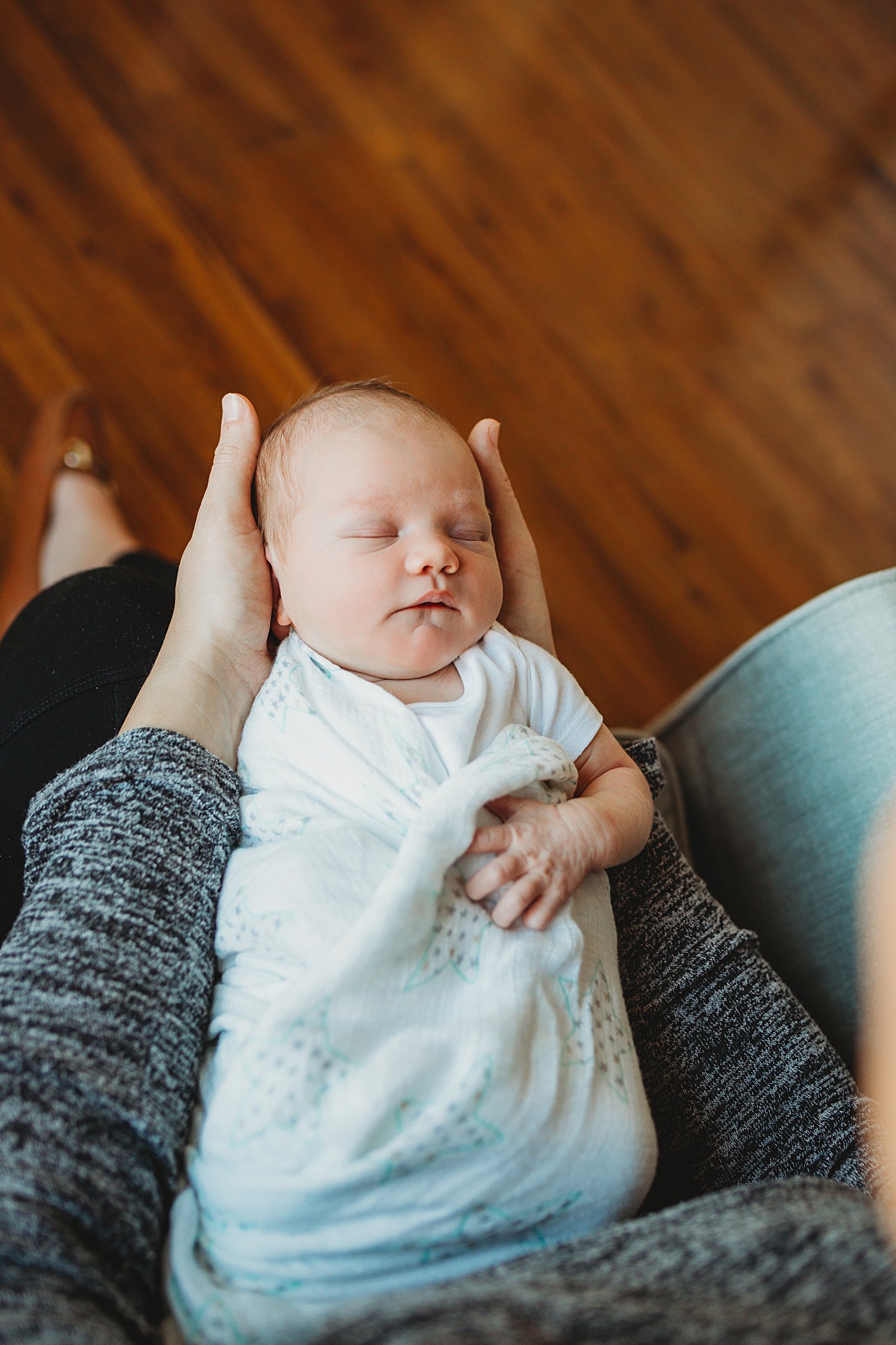 Lifestyle portrait of newborn baby in mom's lap