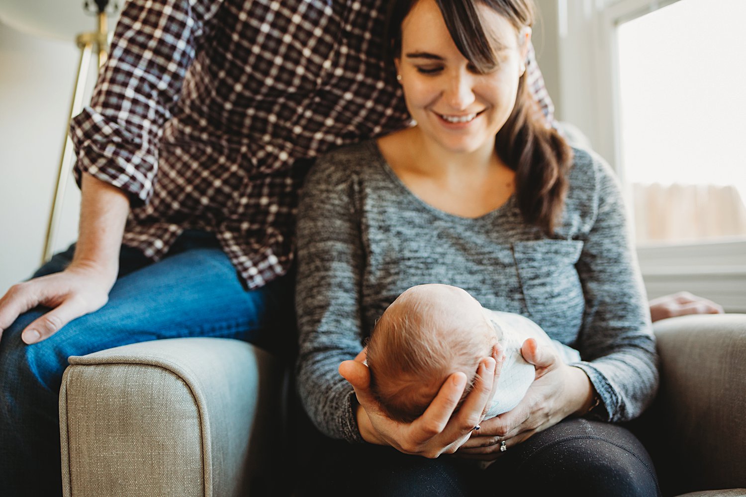 Lifestyle portrait of newborn baby in mom's lap