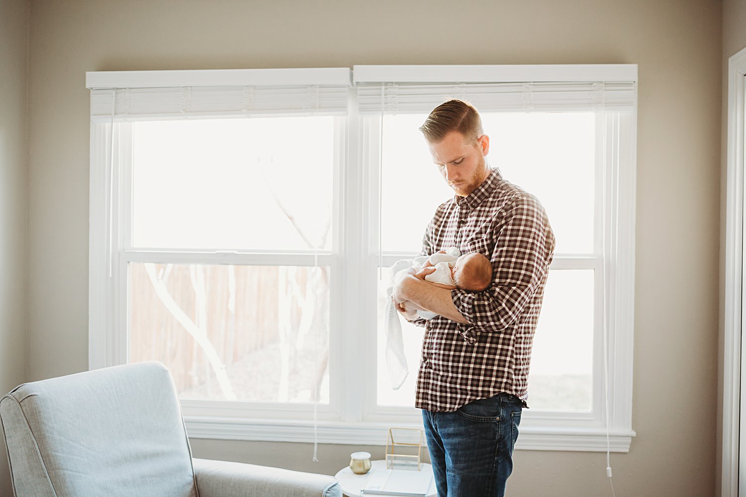 Lifestyle family portrait of dad holding newborn baby