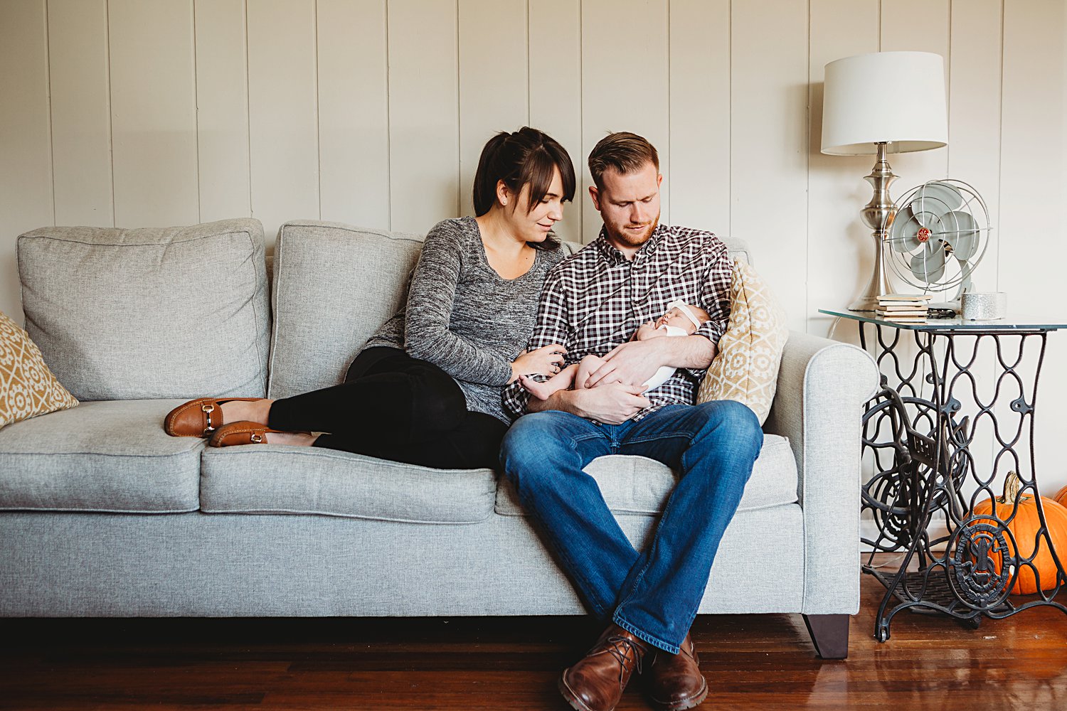 Lifestyle family portrait of parents holding newborn baby