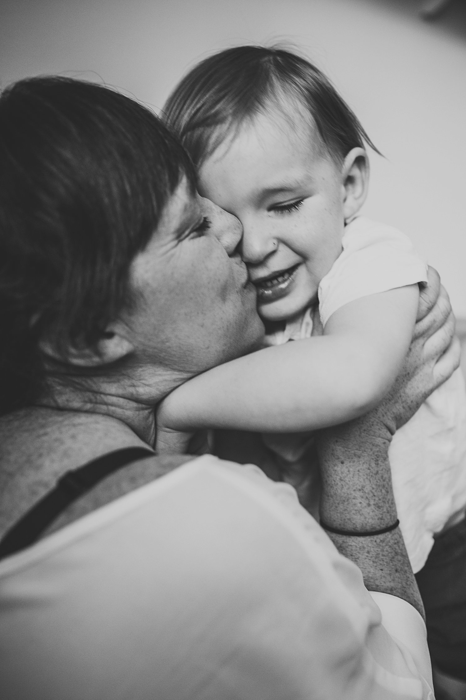 Mom holding son close and kissing his cheek