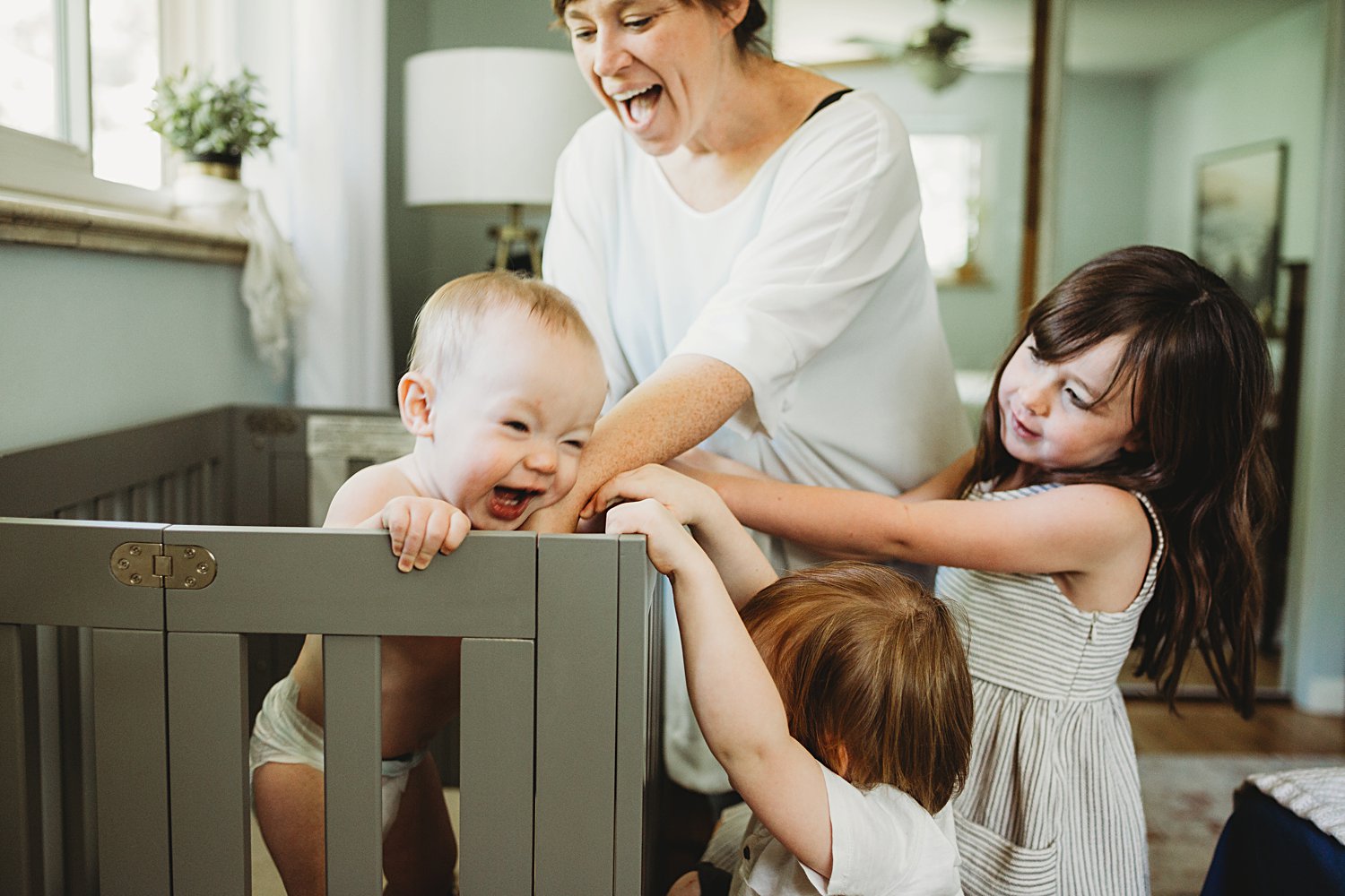 Mom and older siblings go to baby's crib to pick him up