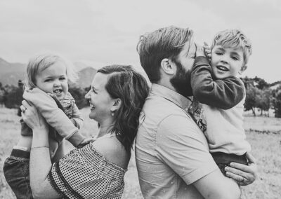 Parents standing back to back holding young boys