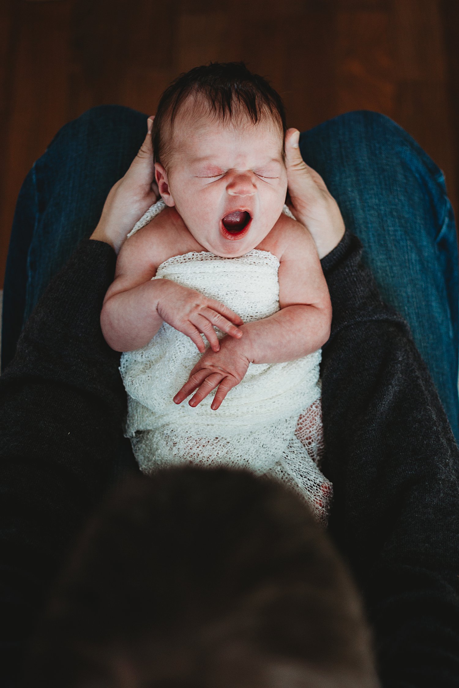 Dad holds newborn baby boy in lap